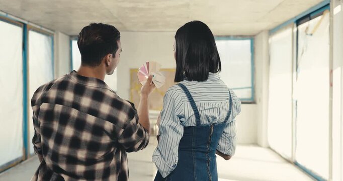 Back, couple and swatch at new house for renovation, design and inspiration of unfinished property. People, talk and color palette at site with paint sample, decor or diy makeover or home improvement