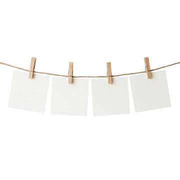 Four empty paper notes hanging on a string with wooden clothespins