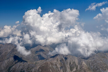 Obraz premium convergence clouds on barren Chisone valley mountains aerial, Italy