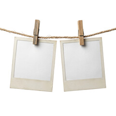 Two empty vintage photo frames hanging on a rope with wooden clothespins © Raja