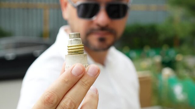 Man holding old ceramic electrical fuse