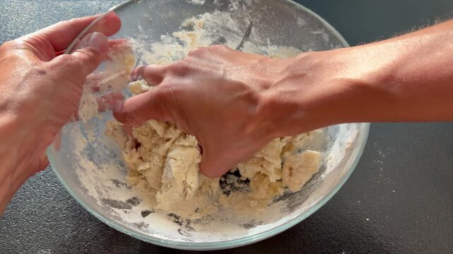 the process of preparing yeast dough. Female hands kneading raw dough