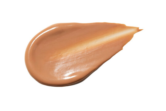 A smooth smear of beige liquid foundation makeup cream on a white surface isolated on a transparent background