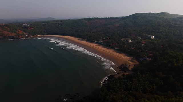 Aerial view rotating around the Kudle Beach, hazy evening in Gokarna, India
