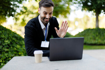 Man waving greeting during outdoor video conference meeting © PintoArt