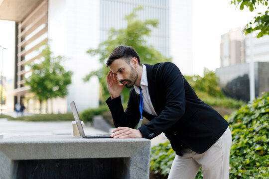 Stressed businessman struggling with remote work outdoors