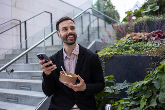Professional man enjoying outdoor lunch break with smartphone