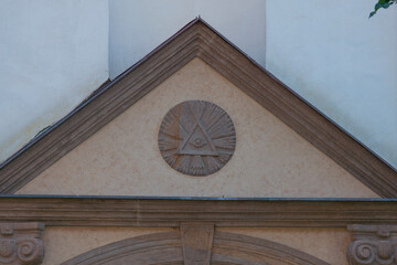 eye of providence carved relief triangular pediment stone church facade beige wall architectural detail slovakia religious symbol concept of religion, history, architecture © Lana Pietukhova
