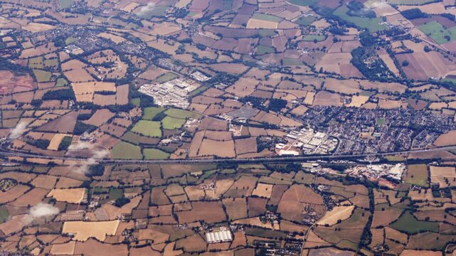 High Aerial View Above M5 Motorway with Surrounding English Countryside with Small Village of Willand in Devon with Industrial Estates.