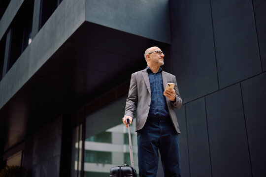 Below view of entrepreneur using smart phone app while being on business trip.