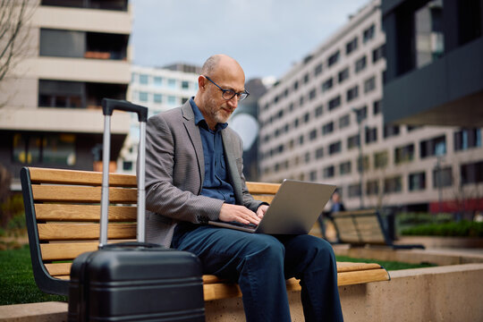 Smiling entrepreneur working laptop during business travel.