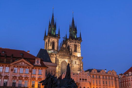 Tyn Church and Jan Hus memorial stand illuminated at night in Prague