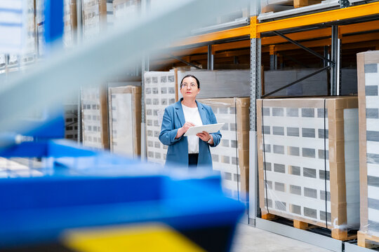 Businesswoman checks inventory on a tablet in the warehouse