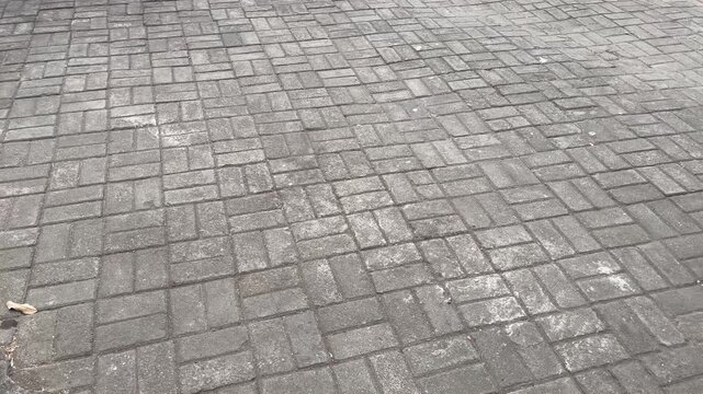 Wide angle view of grey concrete paving blocks texture background