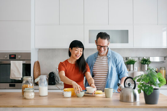 Couple preparing healthy breakfast together in modern kitchen