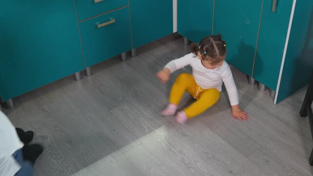 Caucasian female educator supports a little girl's first sweeping practice in a kindergarten classroom. The activity combines practical life education with motor development and independent learning. 
