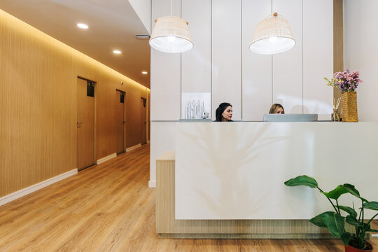 A receptionist works at the desk in a modern beauty clinic