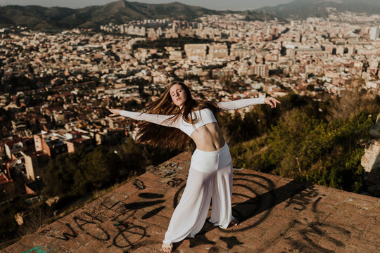 Young woman performs contemporary dance outdoors above Barcelona