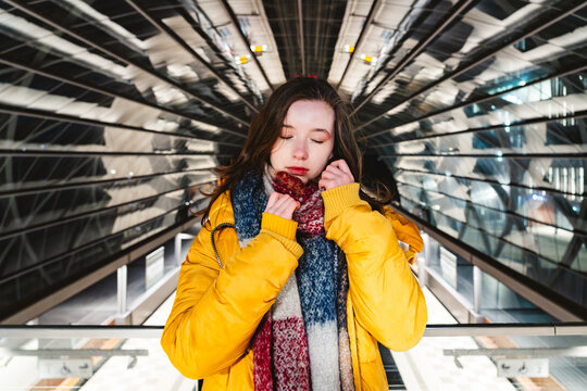 Confident youth with scarf in modern urban architecture at night