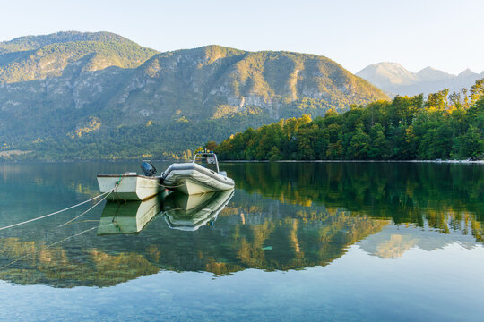 Two boats float on the calm water of Lake Bohinj in Slovenia