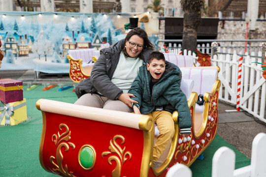 Mother and son with disability enjoying a Christmas fair attraction