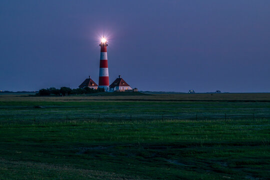 Illuminated Westerheversand lighthouse at night in Germany