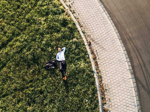Businessman lying on traffic island in roundabout