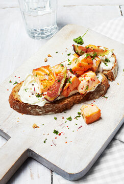 Healthy open sandwich with salmon and fig on a cutting board
