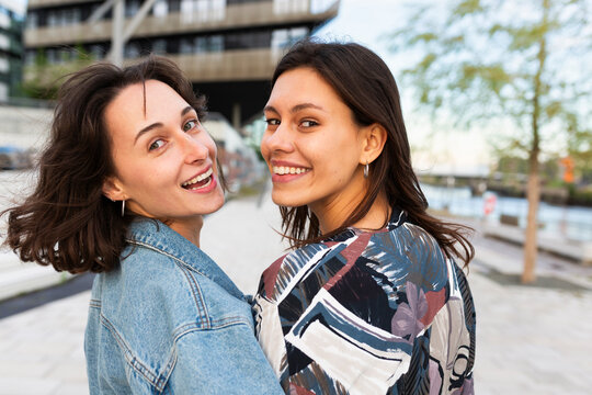 Female friends smile at the camera in Hamburg Hafencity