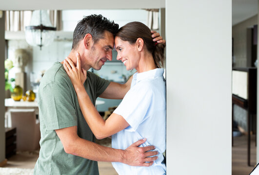 A loving couple shares a tender embrace at home