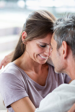A happy man and woman share an intimate embrace in the living room