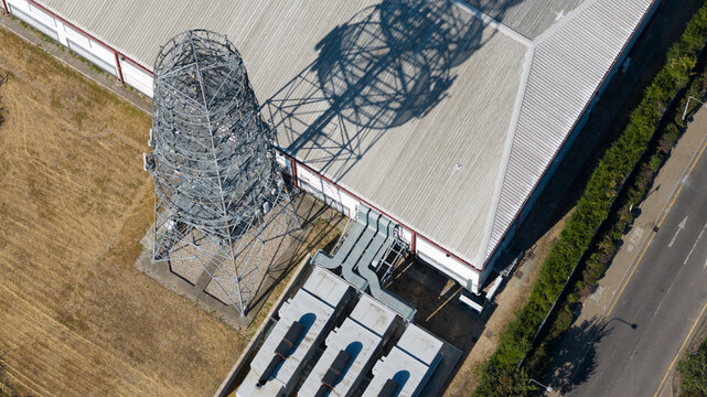 A communication tower casts a shadow on a data center roof
