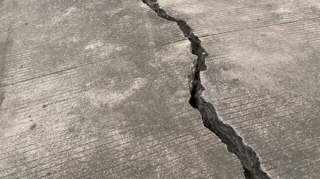 Top view of deep long crack on concrete ground texture