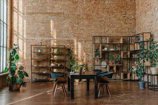 Modern loft office interior with wooden desk and brick wall