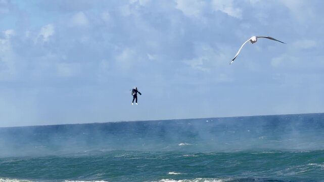 Man Flying Jet Suit Over Ocean Waves in Surfers Paradise