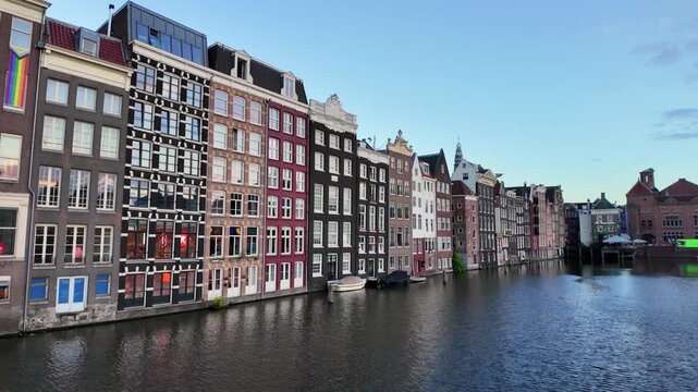 Typical scene with canal-side houses along the Damrak in Amsterdam, Netherlands