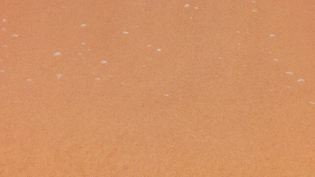 Pure coral sand washed by transparent ocean water on a tropical beach in slow motion. sand on the beach close-up. Beach video from vacation.