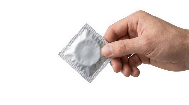 A person holding a square silver foil condom wrapper isolated on a white background with wrapper against plain hand holds square contraception prophylactic preventative reproductive transmission
