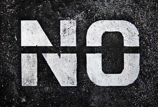 Mot "NO" Peint au Pochoir Blanc sur Asphalte Noir &agrave; Haut Contraste pour &Eacute;v&eacute;nements, Articles Conceptuels et Banni&egrave;res