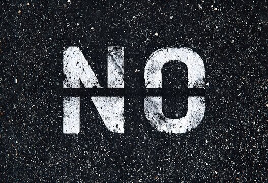 Mot "NO" Peint au Pochoir Blanc sur Asphalte Noir &agrave; Haut Contraste pour &Eacute;v&eacute;nements, Articles Conceptuels et Banni&egrave;res