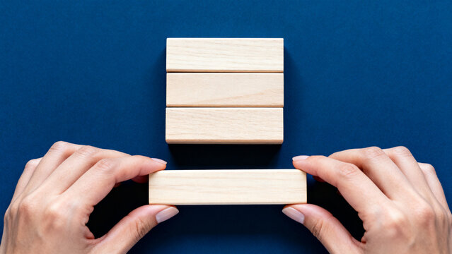 Hand Placing Wooden Block with SOMETHING NEW IS COMING Text on Deep Blue Background &mdash; New Beginning Concept