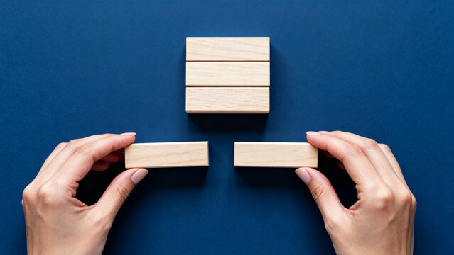 Hand Placing Wooden Block with SOMETHING NEW IS COMING Text on Deep Blue Background &mdash; New Beginning Concept