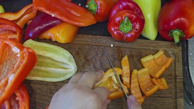 Fresh bell peppers are washed under running water and prepared for slicing and canning. Homemade preserves for the winter, making vegetable 