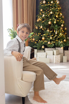 Happy child on Christmas, enjoying some quality time, opening presents, kids on Christmas eve in decorated home