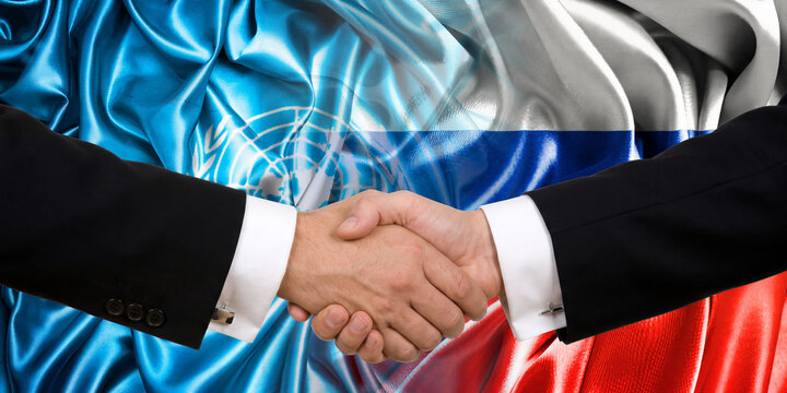 Handshake between Russia and the UN, international friendship, background with flags. Flags.