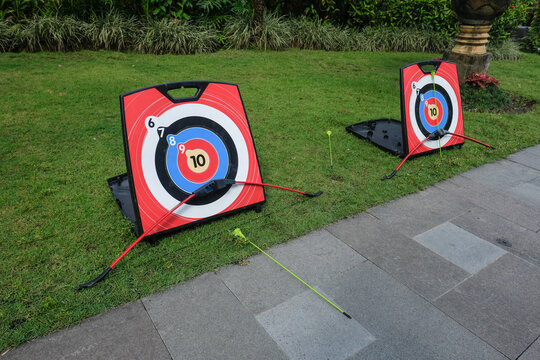 Archery targets and bows set up on a grassy outdoor practice area, illustrating target shooting, recreational archery, training and outdoor sport.