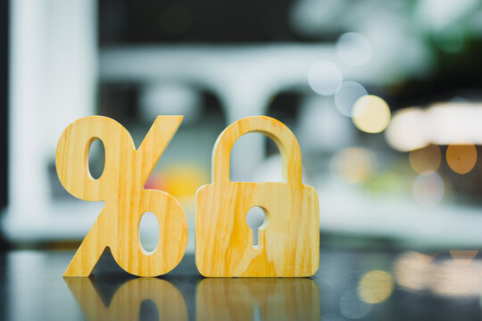  Financial security and fixed interest rate concept with wooden percent symbol and closed padlock on table for mortgage loan protection, deposit yield guarantee and banking capital privacy.