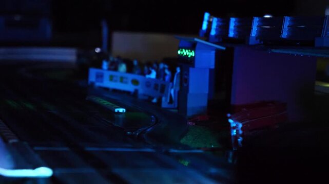 miniature slot car racing at night with illuminated headlights on track