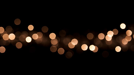 Obraz premium Golden bokeh lights on a black background. Horizontal band of blurred festive string lights. Abstract glowing holiday overlay.
