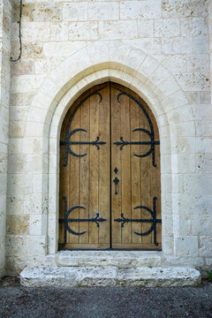 Arched wooden church door with wrought iron hinges, Gers, Saint Georges, France